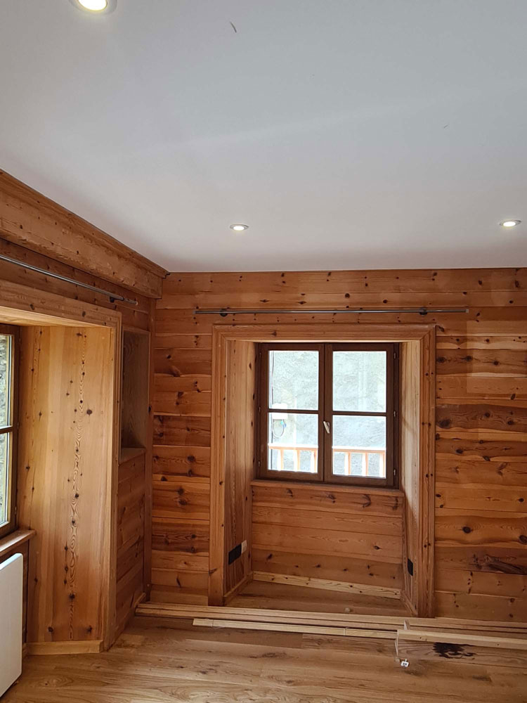 Chambre de chalet finie avec mezzanine bois et éclairage encastré
